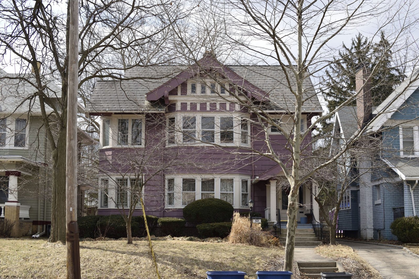 Red brick house behind bare trees